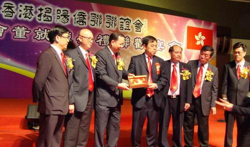 揭東縣副縣長(zhǎng)魏文忠代表揭東縣委縣政府、香港揭陽(yáng)僑聯(lián)聯(lián)誼會(huì)主席邱長(zhǎng)喜代表新一屆會(huì)董，在就職典禮聯(lián)歡宴會(huì)上互贈(zèng)紀(jì)念品。揭東縣僑聯(lián) 供圖 