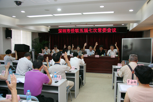 會(huì)上，市僑聯(lián)常委們舉手表決有關(guān)人事事項(xiàng)。李恩 攝