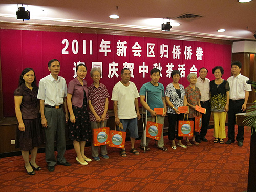 領(lǐng)導(dǎo)嘉賓向困難歸僑送月餅和中秋慰問金。