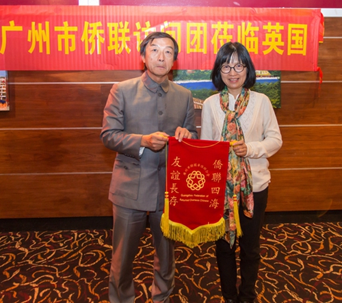 吳少姬副主席向倫敦華人社區(qū)中心副主席陳顯耀贈送錦旗
