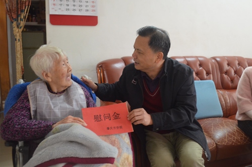 2市僑聯(lián)一級(jí)調(diào)研員黃志堅(jiān)（右）向印尼歸僑郭惠英送上慰問(wèn)金_副本.jpg
